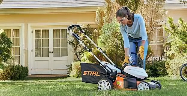 Woman checking STIHL Lawn Mowers in her grass yard